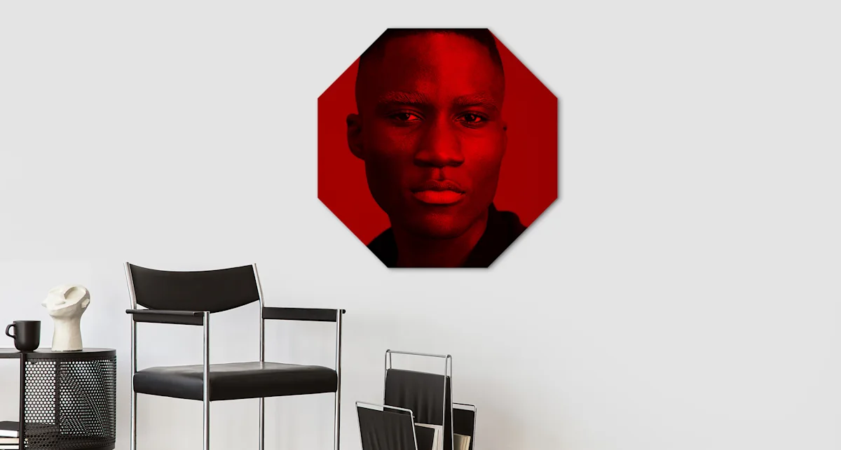 PDP | Round Format & Shapes | Big Picture Slider Section > Octagon | Slide #4 | Media #1 A portrait of a man, depicted entirely in the colour red, hangs Octagon size on a wall.