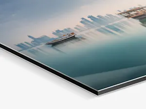 Abstract cityscape photo split into horizontal segments, showing skyscrapers reflected in turquoise water against a pale blue sky