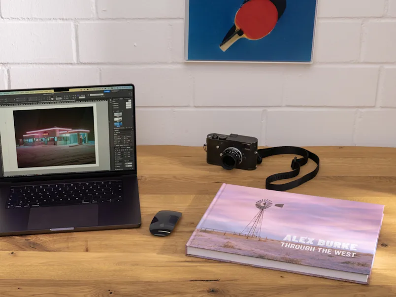PDP | Bildband | Product Selector Section (US, BE, IT, ES, EU) | Media #4 | Image Closed coffee table book on work table next to laptop